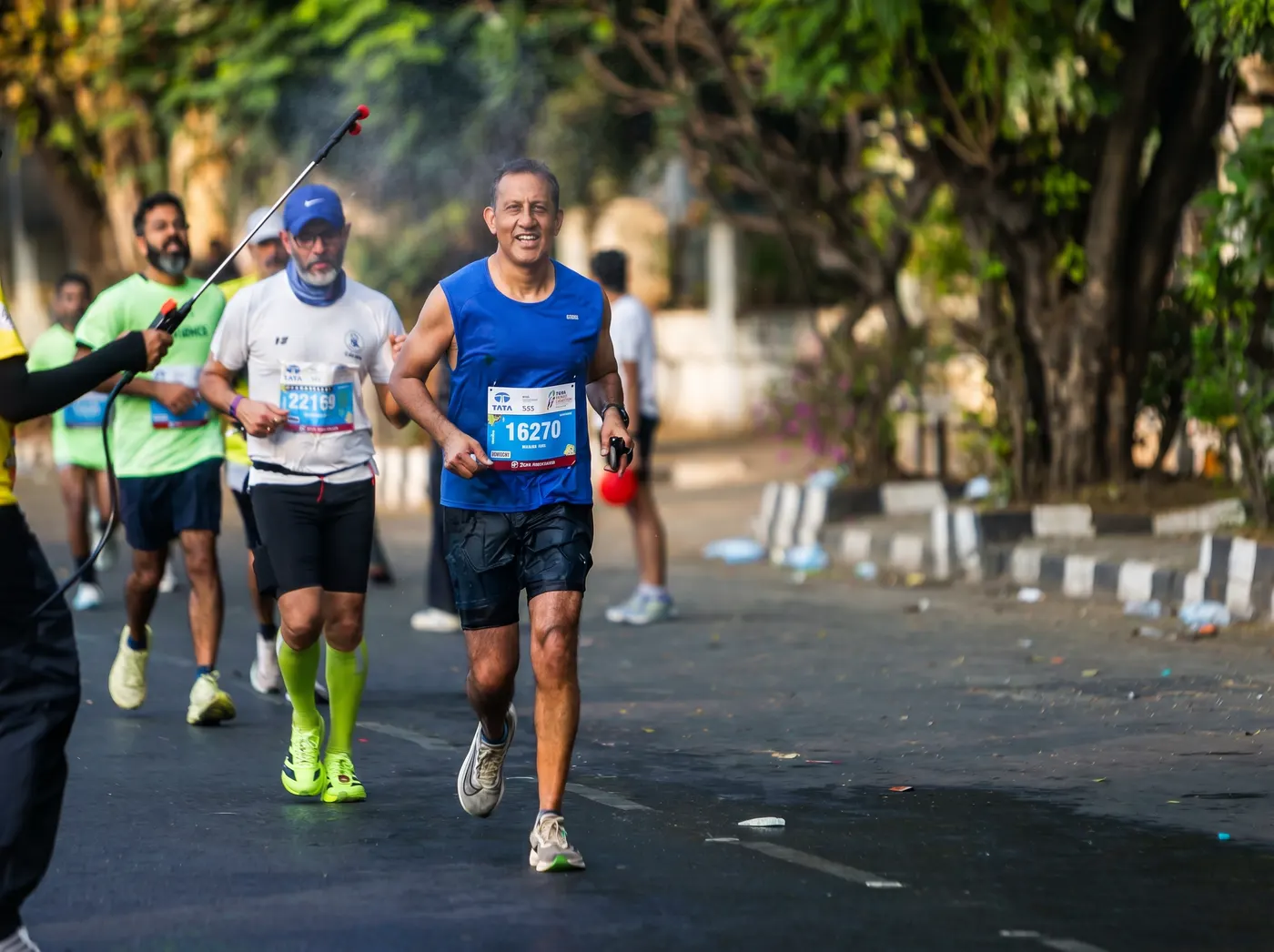 Runners on a tree-lined Jaipur road during a RunActiv race.
