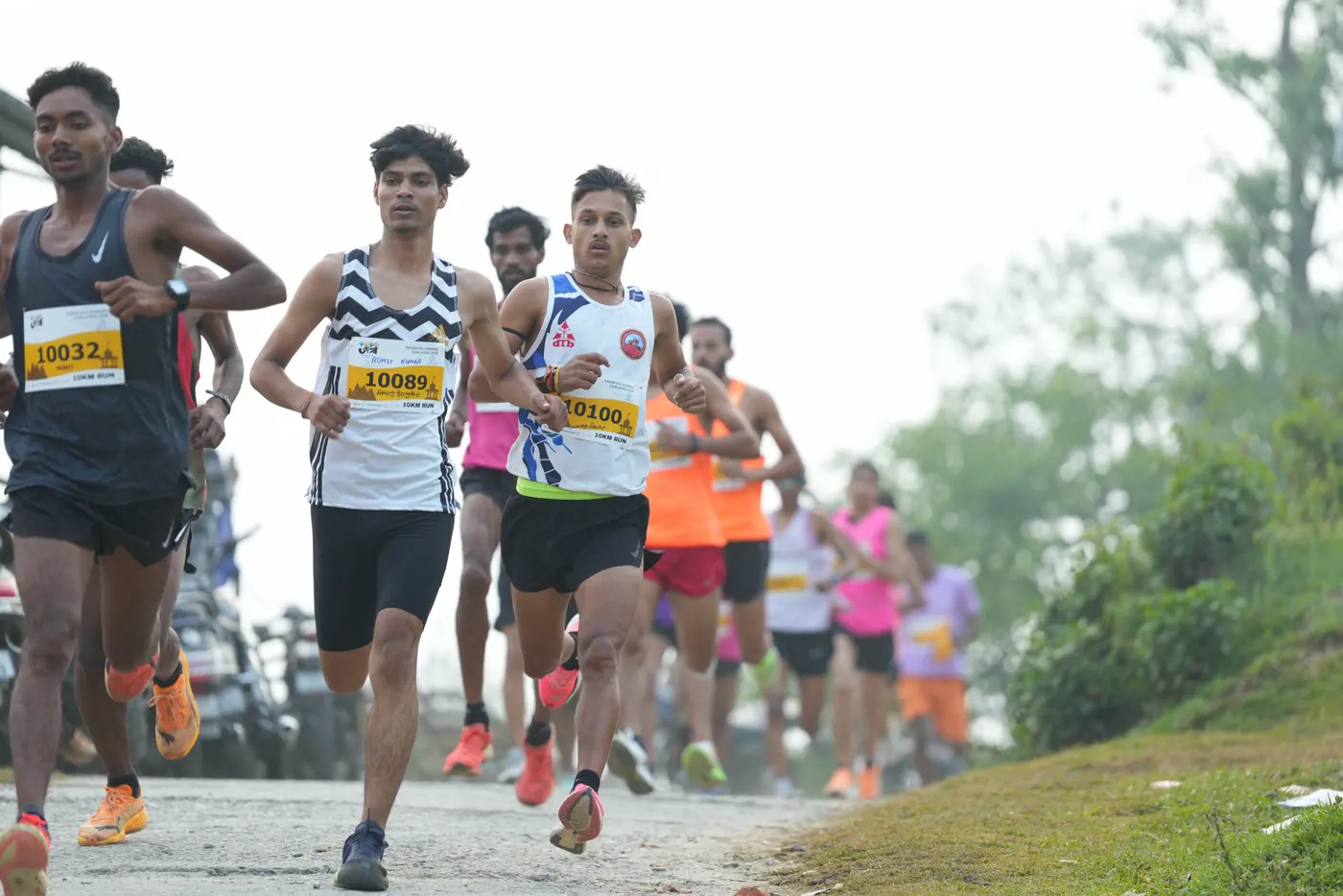 Runners climbing a misty hill road at the Kasar Hill Running Challenge.